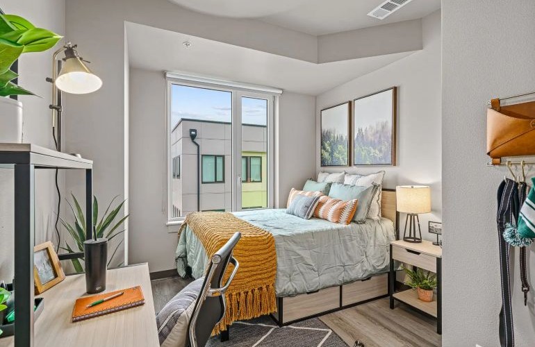 Fully furnished room with bed, desk, and nightstand